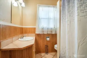 Bathroom with tile flooring and full bath with shower.