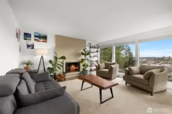 Inviting living room anchored by a cozy fireplace and framed by big windows with neighborhood views.