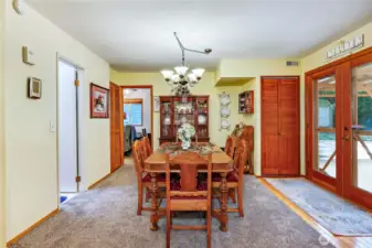 A view of the dining room with the 3/4 bath on the left and den/office through the door beyond.