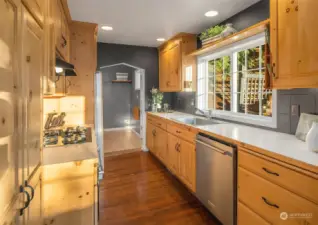 Kitchen with stainless steel appliance, knotty pine cabinets and connected to utility room.