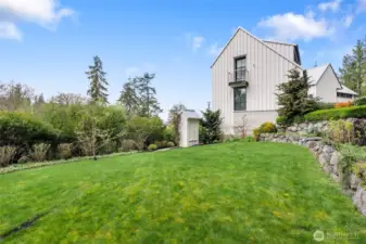 Varied landscaping includes a beautiful, lush lawn. The balcony is off the 2nd primary suite.