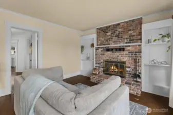 Cozy family room flanked by built-ins, with the stunning floor-to-ceiling brick fireplace.
