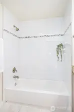 Upstairs Main Bathroom has a full tub with tile.