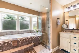 Jetted soaking tub in the ensuite with opposing His/Her's vanities.