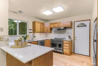 A 2024 kitchen remodel brings sleek functionality with quartz counters, new tile backsplash, and stainless appliances. The large picture window brings in the trees while you cook on a high-end gas range.
