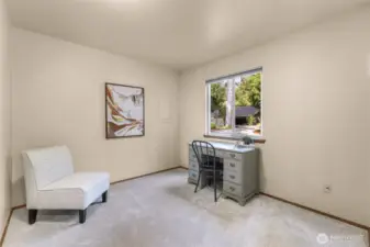 The third bedroom overlooks the front drive, making it ideal as a guest room, craft space, or office. Soft carpeting and a large window provide comfort and light.