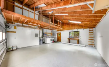 The oversized garage doubles as a workshop, complete with ample lighting, built-ins, and storage. Durable flooring and vaulted ceilings make it a versatile and functional space.