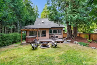 The rear view shows how the deck and hot tub connect seamlessly to the home’s main living areas. Relax under the covered patio or soak under the stars in this backyard retreat.