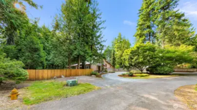 A long private drive curves gently into the property, revealing a peaceful setting tucked among the trees. The home’s cul-de-sac location offers seclusion and low traffic for added tranquility.