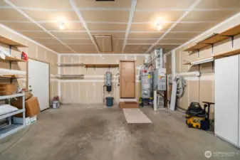 large 2 car garage. This photo show the newer gas hot water heater and built in vacuum cleaner system. Everything is so convenient. Man door leads to the side walk to the back yard.
