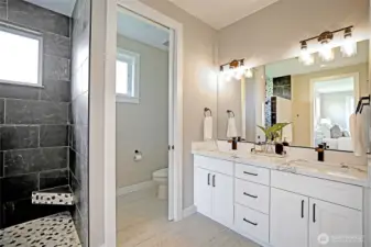Beautiful primary suite includes heated tile floors, a custom walk-in shower, and generous closet space.