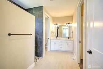 Beautiful primary suite includes heated tile floors, a custom walk-in shower, and generous closet space.