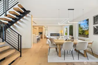 View from the dining area highlights the dramatic vertical volume and open staircase.