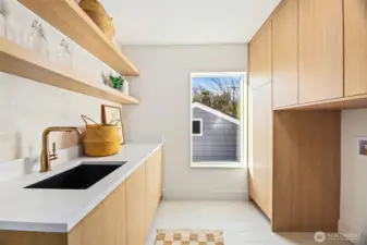 High-end laundry and utility room with custom cabinetry and abundant workspace.