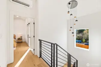 View from the upper landing highlighting the architectural floating stairs and open vertical volume.