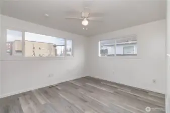 Primary bedroom with ceiling fan and big windows for that natural light