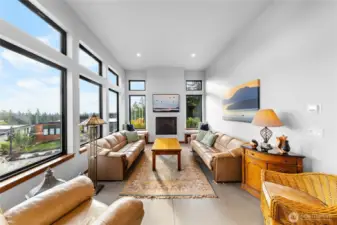 Gas fireplace in the living room with double windows that enhance the tall ceilings.