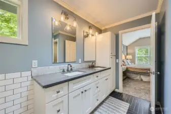 The primary bathroom also boasts stunning geometrically-designed tile floor with contrasting tile wall from floor to countertops. Dual undermount sinks with high-end fixtures and lighting.
