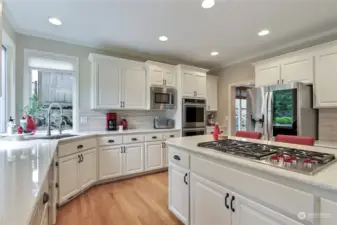 Chef's kitchen features Wolf 5 gas burner cooktop, 2 convection ovens, LG refrigerator, walk in pantry & timeless quartz countertops