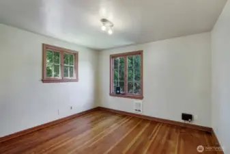 Front bedroom with pine hardwood floors, cedar lined closet and 2 large classic windows.