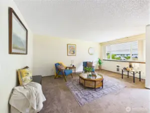 The large window lets in tons of natural light and makes this front room bright.