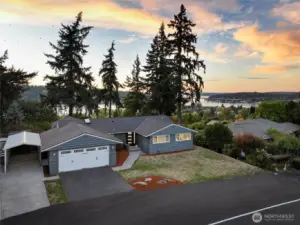 Front home with dramatic lake and city skylines behind