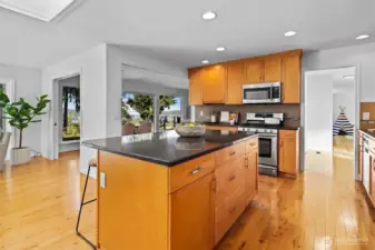Updated timeless design kitchen with natural wood shaker cabinets, stainless steel appliances and large island with seating