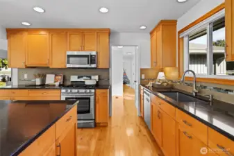 Updated timeless design kitchen with natural wood shaker cabinets, stainless steel appliances and large island with seating