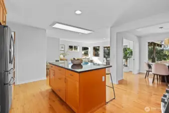 Updated timeless design kitchen with natural wood shaker cabinets, stainless steel appliances and large island with seating