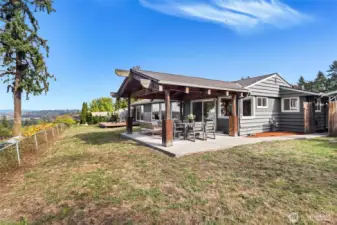 Backyard with multiple entertaining areas including covered patio