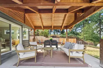 Backyard with multiple entertaining areas including covered patio