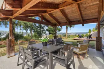 Backyard with multiple entertaining areas including covered patio