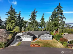 Front home with dramatic lake and city skylines behind