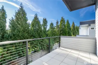 Primary bedroom with private south facing balcony overlooking backyard