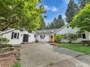 Charming white home with bold orange door and private driveway