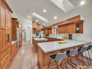 Chef’s kitchen with skylights, stone counters, and wood cabinetry