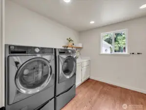 Laundry room with washer, dryer, sink, and storage cabinetry