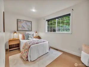 Bright guest bedroom with large window and garden views