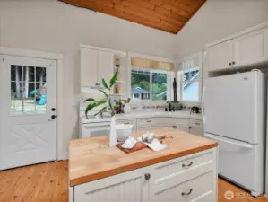 Charming kitchen with island, beadboard cabinets, and views