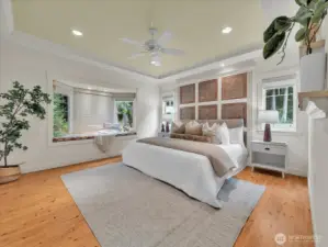 Luxurious primary suite with window seat and custom wall detail