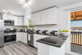 Quality white cabinetry, granite counters, tiled backsplash, stainless appliances