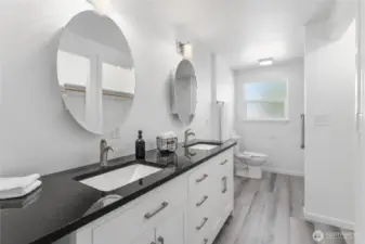 Sophisticated en-suite retreat with jetted walk-in tub, dual granite vanities, and upscale designer finishes