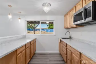 Versatile lower level ideal for multi-generational living or rental income—featuring a second kitchen, two bedrooms, expansive family room, utility space, bathroom, storage, and a private entrance