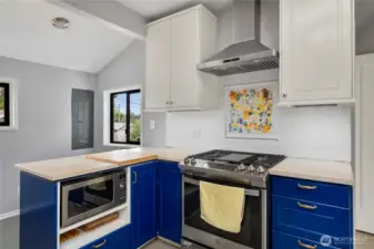 Cooking corner of kitchen, gas stove and excellent counter space.