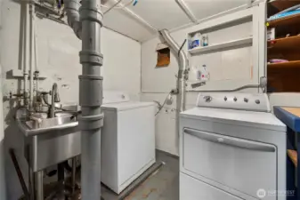 The laundry area boast a newer stainless steele sink and lots of storage space and area for folding clothes