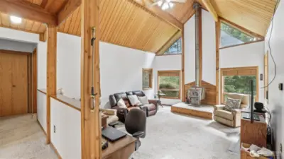 Vaulted wood ceilings with exposed beams throughout. Cozy wood burning fireplace heats the entire home.