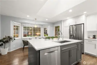 Notice the stainless appliances and pantry cabinet to the left of the fridge.