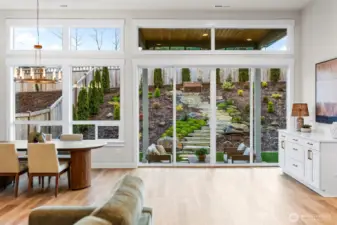 Wall of windows in this open-concept living space. All windows wrapped with Millwork to complete the finished modern luxury look, with durable flooring that helps blend the inside and outside seamlessly. South facing windows let the light pour into your living space.