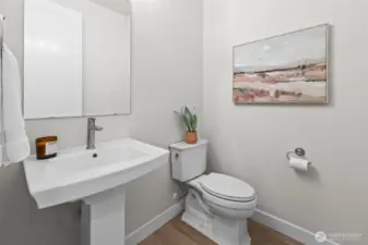 Convenient guest half bathroom located just off the main hallway, offering a stylish and functional powder room within this thoughtfully upgraded newer construction home in McCormick Trails, Port Orchard.
