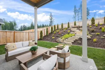 Covered outdoor living space creates a seamless transition from inside to out, offering a comfortable setting for year-round Pacific Northwest entertaining.
